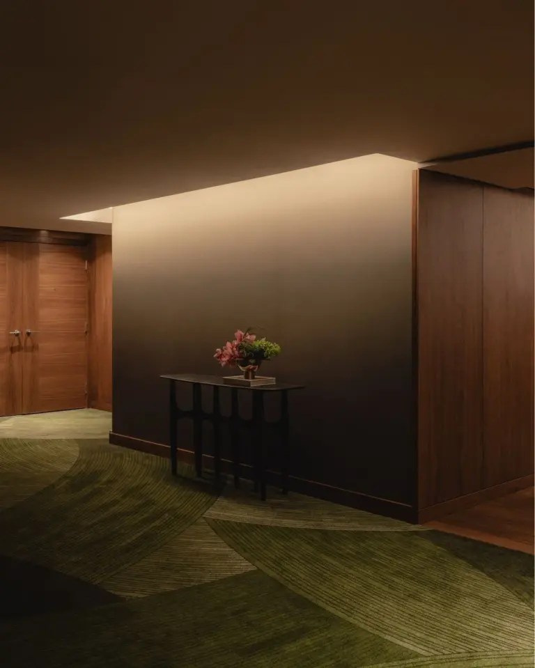 Hotel corridor with green patterned carpet tiles in low evening light